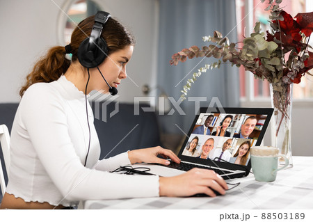 Young woman talking with colleagues during video conference at home Young woman talking with colleagues during video conference at home 88503189