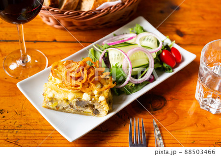 Quiche Lorraine slice with fried onions and vegetable salad 88503466