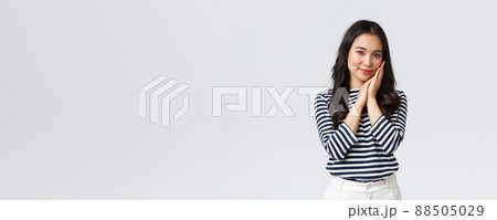 Lifestyle, people emotions and casual concept. Tender asian woman with beautiful face, touching cheek gently and gazing camera, advertising beauty product, cosmetics or skincare items 88505029