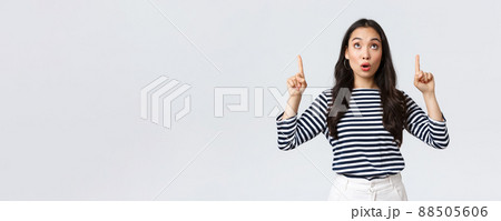 Lifestyle, beauty and fashion, people emotions concept. Surprised and intrigued attractive korean girl shopping, found good sale, pointing fingers up at top banner and say wow Lifestyle, beauty and fashion, people emotions concept. Surprised and intrigued attractive korean girl shopping, found good sale, pointing fingers up at top banner and say wow 88505606