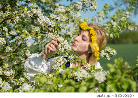 Beautiful feminime woman in national dress with white spring flowers Beautiful feminime woman in national dress with white spring flowers 88505957
