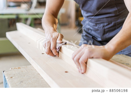 Crop artisan sanding wooden board in workshop 88506198