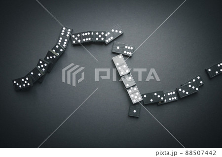 Black dominoes chain on dark table background 88507442