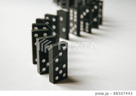 Black dominoes chain on white table background Black dominoes chain on white table background 88507443