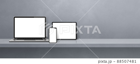 Laptop, mobile phone and digital tablet pc on grey wall shelf. Banner background 88507481