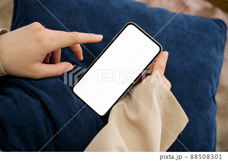 Close-up image, Female using a smartphone in her living room. 88508301