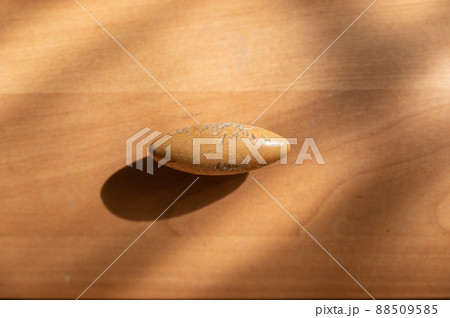Close-up of a brown oval wooden cabinet handle. An old scratched hilt. Close-up of a brown oval wooden cabinet handle. An old scratched hilt. 88509585