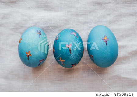 Pressed flower Easter eggs on beige tablecloth. 88509813