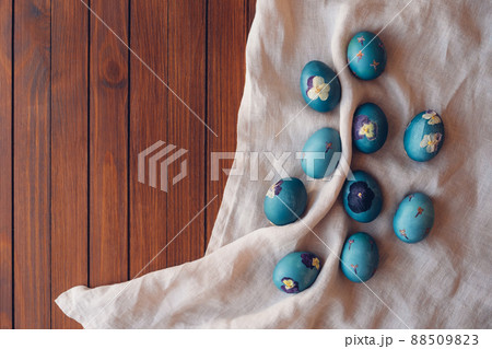 Pressed flower Easter eggs on beige tablecloth. Pressed flower Easter eggs on beige tablecloth. 88509823