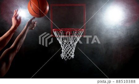 Basketball going through the basket on black backgorund 88510388