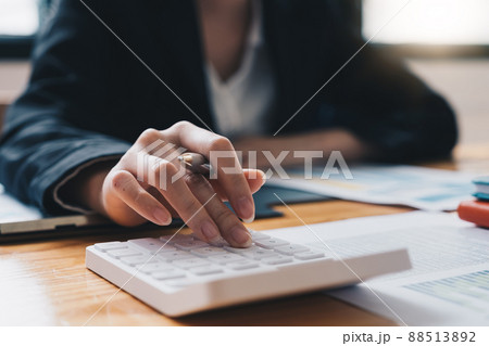Accountant working on desk using calculator for calculate finance report 88513892
