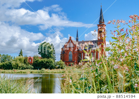 Scenic view across the lake to the Roman Catholic Church of St. Anthony in Postavy, Belarus. 88514594
