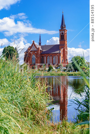 Scenic view across the lake to the Roman Catholic Church of St. Anthony in Postavy, Belarus. 88514595