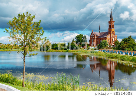 Scenic view across the lake to the Roman Catholic Church of St. Anthony in Postavy, Belarus. 88514608