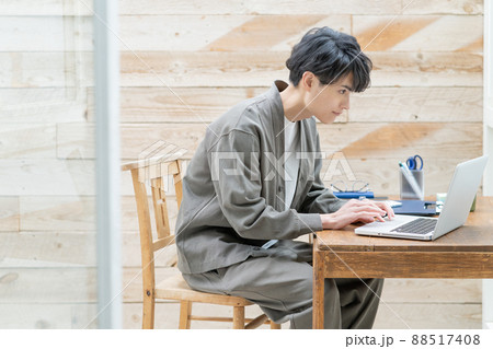自宅のテラスでリモートワークをする若い男性 88517408