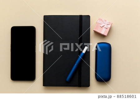 Iqos electronic blue cigarette on a beige background. Iqos electronic blue cigarette on a beige background. 88518601