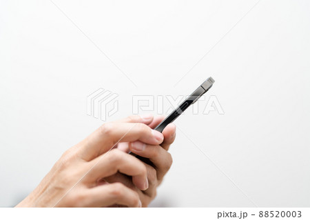 男性がスマホを操作している　男性の手とスマホのクローズアップ 88520003