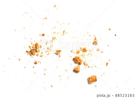 Scattered crumbs of vanilla chip butter cookies isolated on white background. Close-up view of brown crackers. Macro shot of yellow biscuit cake leftovers for your design 88523163
