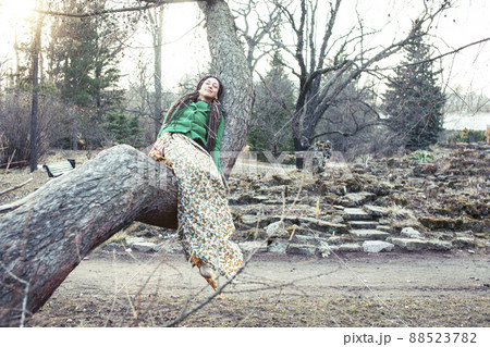 young adorable pretty girl with pigtails hairstyle smiling outside among trees young adorable pretty girl with pigtails hairstyle smiling outside among trees 88523782