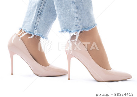 Slender female legs in patent leather shoes with high heels. Light blue ripped jeans. Fashion and Style. Side view Slender female legs in patent leather shoes with high heels. Light blue ripped jeans. Fashion and Style. Side view 88524415