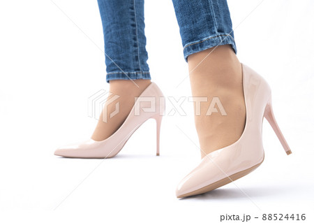 Slender female legs in patent leather shoes with high heels. Dark blue jeans. Fashion and Style. Side view 88524416