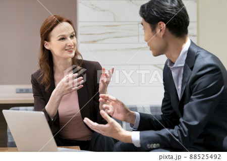 日本人男性に向かって話す外国人の女性　グローバルビジネス  英会話スクールイメージ 88525492