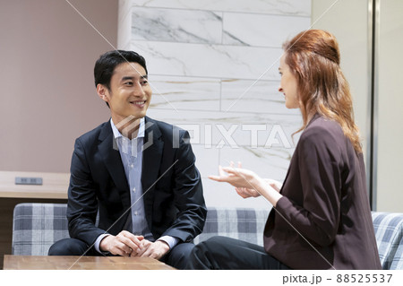 向き合って話をする外国人女性と日本人の男性　グローバルビジネス  英会話スクールイメージ 88525537