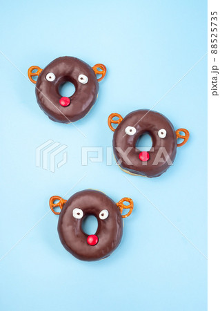 Christmas reindeers from chocolate doughnut, pretzel cookie, marshmallow and candy, vertical Christmas reindeers from chocolate doughnut, pretzel cookie, marshmallow and candy, vertical 88525735