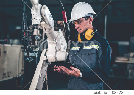 Young factory worker working with adept robotic arm 88528319