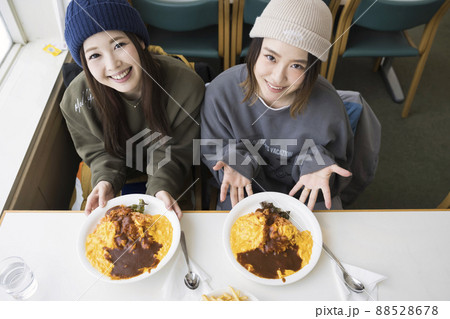 スキー場のレストランで料理を見せる若い女性 88528678