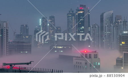 Dubai skyscrapers with morning fog in business bay district night to day timelapse. Dubai skyscrapers with morning fog in business bay district night to day timelapse. 88530904