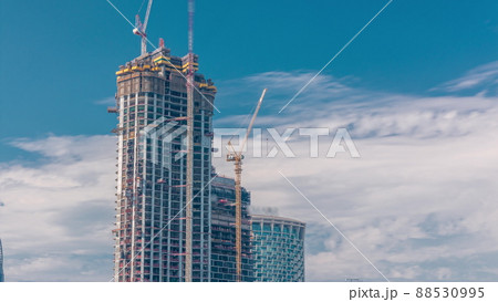 Cranes working on modern constraction site works of new skyscraper timelapse 88530995