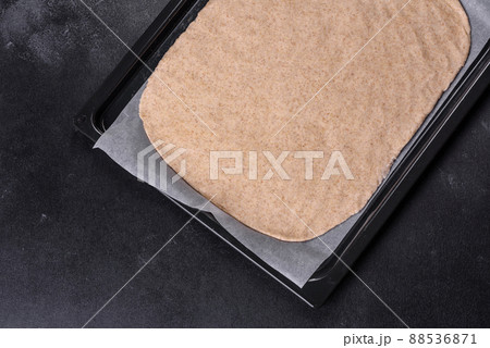 Rolled out prepared raw dough on parchment and baking sheet 88536871