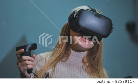 The girl plays virtual reality games in the club. The girl plays virtual reality games in the club. 88539117