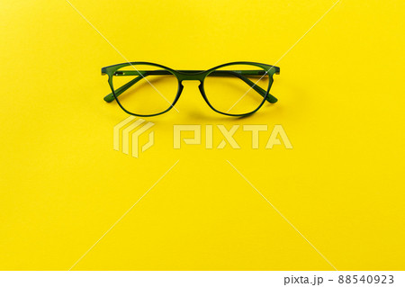 Stylish eyeglasses over yellow background. Optical store, glasses selection, eye test, Stylish eyeglasses over yellow background. Optical store, glasses selection, eye test, 88540923