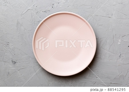 Top view of empty pink plate on cement background. Empty space for your design Top view of empty pink plate on cement background. Empty space for your design 88541295