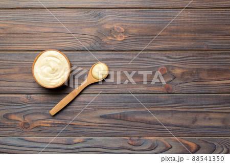 Cheese sauce in wooden bowl with spoon on wood background. Top view with copy space Cheese sauce in wooden bowl with spoon on wood background. Top view with copy space 88541350