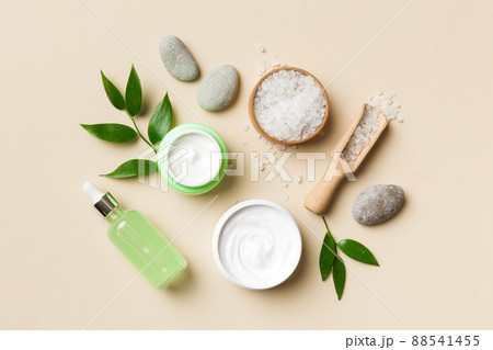 Coconut with jars of coconut oil and cosmetic cream on colored background. Top view. Free space for your text. Natural spa coconut cosmetics and organic treatment concept Coconut Spa composition 88541455