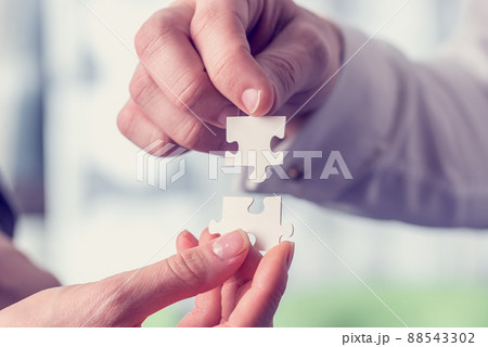 Retro vintage style image of a businesspeople fitting together puzzle pieces Retro vintage style image of a businesspeople fitting together puzzle pieces 88543302