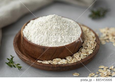 Oat wholegrain flour with oat flakes on wooden table 88545666
