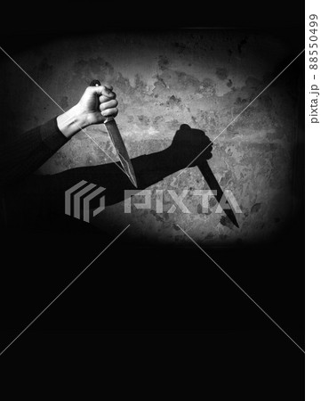 Shadow of the hand holding a big knife Shadow of the hand holding a big knife 88550499