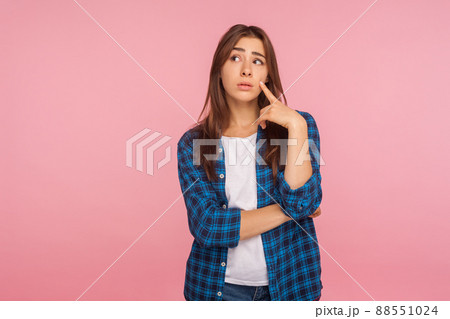 Need to think over difficult decision. Portrait of pensive girl in checkered shirt looking aside with doubtful thoughtful face, pondering intensely concentrating. indoor studio shot, pink background Need to think over difficult decision. Portrait of pensive girl in checkered shirt looking aside with doubtful thoughtful face, pondering intensely concentrating. indoor studio shot, pink background 88551024