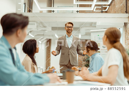 Colleague making a presentation while standing in the office 88552591