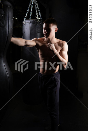 Blows practices bag boxer athlete The the glove black young male body, for strong gloves from fight from caucasian guy, sportswear martial. Backlit victory people, 88553618