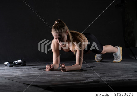 The stands plank girl on in a with the dumbbells floor push-ups looks like a kira knightley girl plank workout, from body fit in exercise from active isolated, sportswear biceps. Wellness sweat 88553679