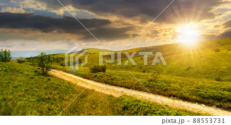 carpathian mountain landscape in summer at sunset. dirt road and hiking trail track. panoramic view of a hilly countryside in evening light. vacation and active lifestyle concept 88553731