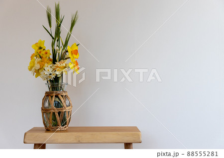 花瓶に生けて室内の白い壁際に置いた水仙の花と麦の穂 花瓶に生けて室内の白い壁際に置いた水仙の花と麦の穂 88555281