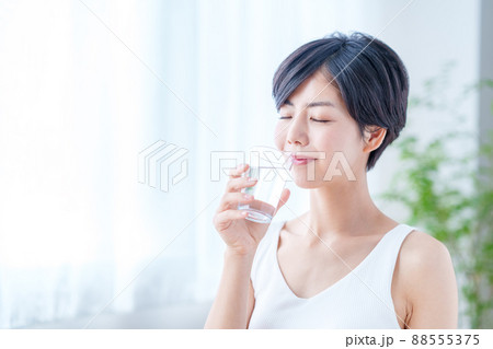 窓際で水を飲む女性 窓際で水を飲む女性 88555375