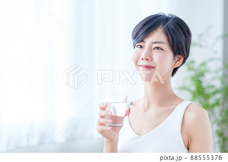 窓際で水を飲む女性 窓際で水を飲む女性 88555376