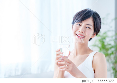 窓際で水を飲む女性 88555377